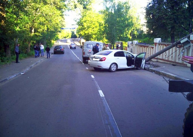 Автомобилистка врезалась в столб, который рухнул на забор фото 2